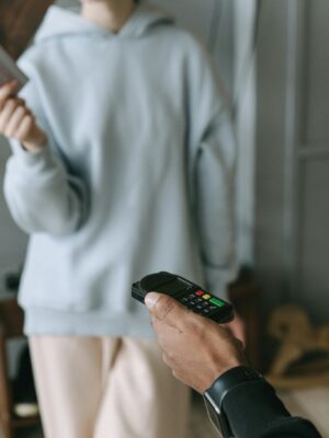 A close-up of a cashless payment using a card reader in a store setting.